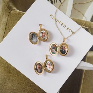 Macro-opname van de gouden ovale medaillon ketting met foto's in open hangers