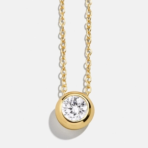 Classic golden birthstone necklace featuring a brilliant round cut white zircon pendant