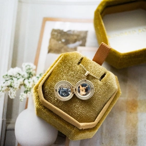 Detail van een open gouden medaillon met twee gekleurde kattenfoto's binnenin
