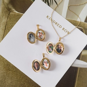 Detail van drie gouden ovale medaillons met aangepaste fotovakjes en een fijne gouden ketting