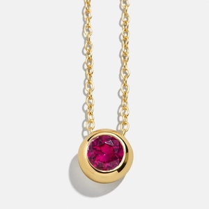 Minimalist gold necklace featuring a round bezel-set ruby red gemstone pendant
