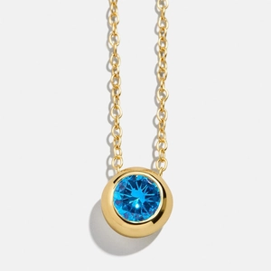 Classic gold birthstone necklace with a round sapphire blue zircon pendant on O-chain