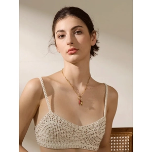 Collana classica a graffetta dorata con pendente a cuore rosso indossata da modella