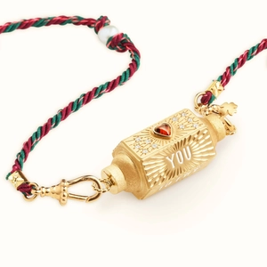 Makro-Detail des goldenen Tarot-Anhängers mit rotem Herz-Edelstein und Webseilkette