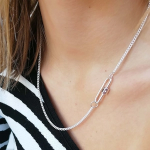 Detail of silver carabiner clip connection on sleek stainless steel chain necklace