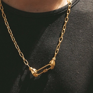 Detail of gold chunky O-chain necklace featuring unique hands clasp and carabiner lock