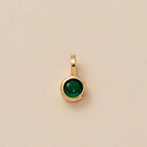 Detailed top view of a dark green round faceted gemstone pendant with gold bezel setting