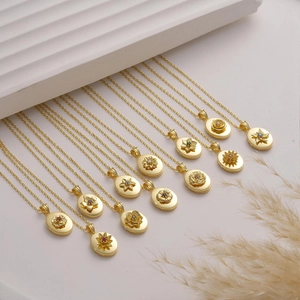 Dettaglio di medaglioni ovali vintage con fiori e pietre natali colorate in oro