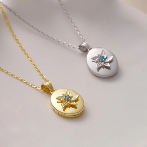 Dettaglio del medaglione ovale vintage con fiore a rilievo e gemma blu incastonata