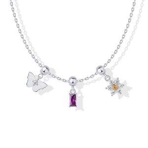 Detail van zilveren ketting met vlinder-, paarse edelsteen- en bloemhangers