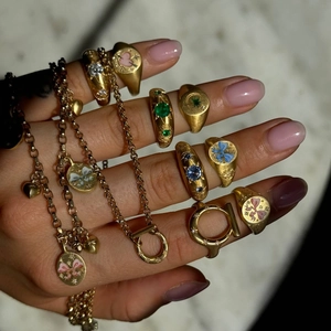 Detailed stack of 18k gold vintage signet rings with enamel patterns and gemstones