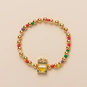 Detail of colorful beads and gold spheres with crown enamel pendant on the charm bracelet