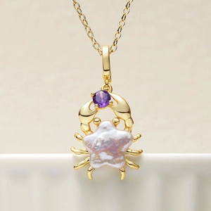 Détail du pendentif crabe en or 18 carats avec perle baroque étoilée et gemme violette
