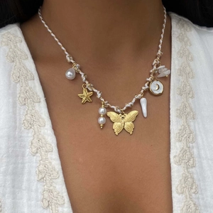 Collana bohémien in corda intrecciata con ciondoli a farfalla, stella marina, conchiglia e perle