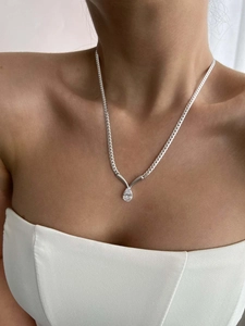Elegant model wearing a silver stainless steel snake chain with a pear-cut zircon pendant