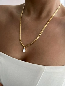 Close-up of golden flat snake chain with sparkling pear-cut zircon teardrop pendant