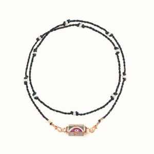 Detail des rotgoldenen Evil Eye Anhängers an einer blau-roten geflochtenen Schnur