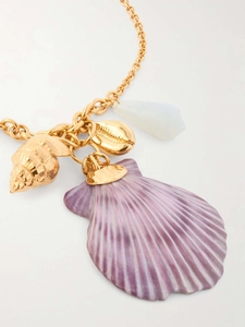 Close-up of golden necklace with purple shell and metallic sea pendants detail