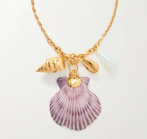Detail of gold necklace with large purple seashell and golden conch beach charms