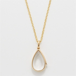 Primer plano del collar con colgante de gota dorada y cristal transparente brillante