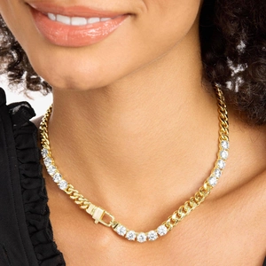 Close-up of gold plated Cuban link and tennis chain necklace worn on a model's neck