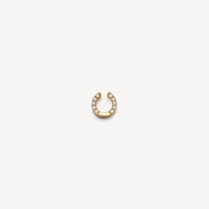 Gros plan sur un pendentif fer à cheval doré orné de cristaux de zircone et design épuré