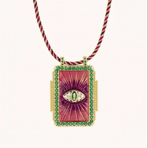 Detail of bohemian tarot pendant necklace with evil eye motif and braided rope cord
