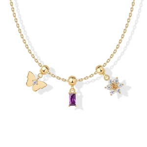 Detail van gouden ketting met vlinder, paarse steen en bloemvormige zirkoon hangers