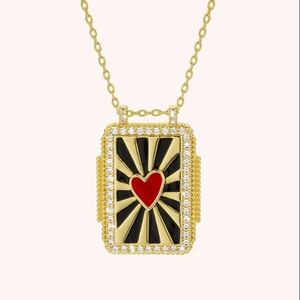 Detail of gold tarot card pendant necklace with red heart and white zircon border