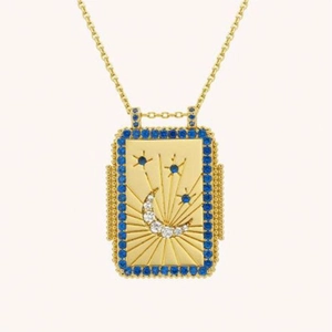 Close-up of golden tarot necklace pendant with blue crystals and sun moon star details