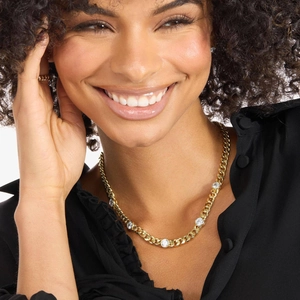Close-up of a gold-plated Cuban link necklace set with sparkling round cubic zirconia stones
