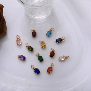 Detalle macro de doce colgantes de circonita de colores con engastes chapados en oro