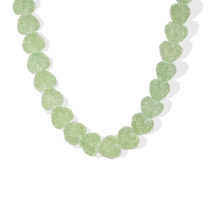 Detalle de collar con cuentas de resina verde claro en forma de corazón efecto escarcha