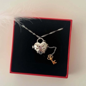Collar de relicario corazón bicolor con gema rosa y llave dorada en caja de regalo