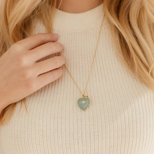 Détail d'un collier cœur plaqué or 18k avec pendentif MOM en émail vert et motif floral
