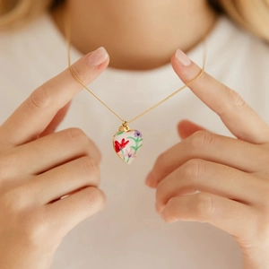 Détail du collier avec pendentif en cœur orné de motifs floraux peints à la main