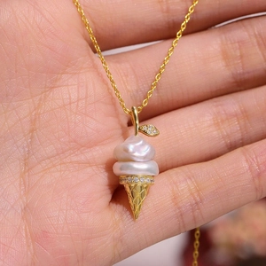 Macro detail of gold ice cream pendant with stacked pearls and fine mesh cone texture