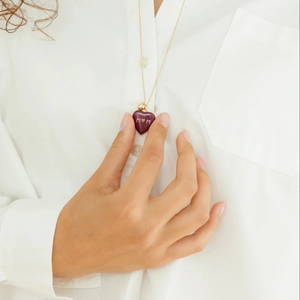 Gros plan d'un médaillon cœur doré 18 carats avec émail violet et gravure MOM sur collier