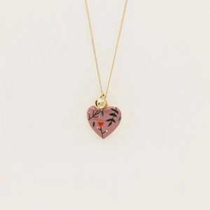 Détail du pendentif cœur en émail rose avec branche florale peinte et chaîne dorée fine