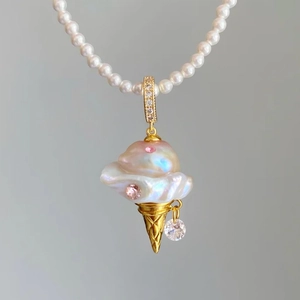 Macro detail of ice cream cone pendant with baroque pearl and pink gems on a pearl chain