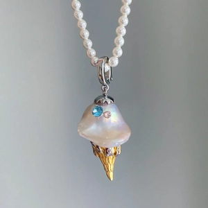 Detail of baroque pearl ice cream cone pendant with pink and blue gems on a pearl necklace