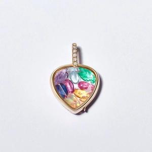 Vue macro d'un pendentif cœur en or 18k rempli de pierres précieuses multicolores