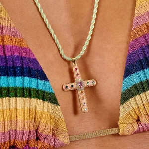 Détail d'un pendentif croix coloré avec gemmes arc-en-ciel sur chaîne torsadée verte