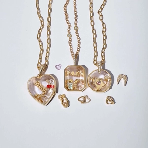 Detail van 18k gouden medaillon kettingen met transparante kast en MAMA thema bedels
