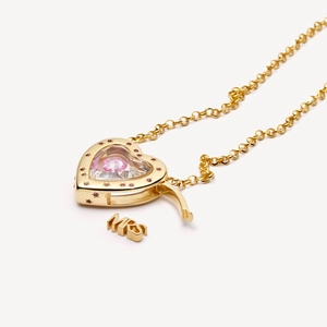Gros plan détaillé du pendentif médaillon coeur avec pierre rose et collier Mrs