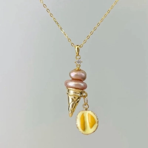 Detail of ice cream cone pendant with pink pearls and gold plating in macro view