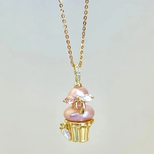 Detailed macro view of 18k gold plated necklace with pink pearl ice cream shaped pendant