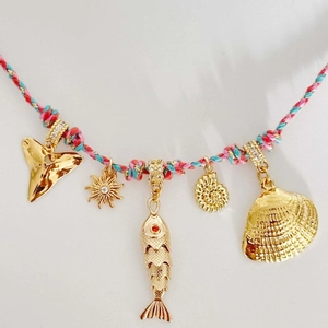 Colorful cord necklace with gold shark tooth, shell, and sun pendants with tiny crystals