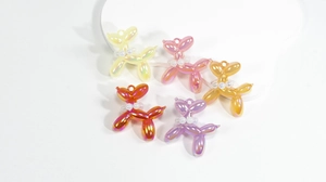 Macro detail of colorful resin balloon dog charms with pearl collars for DIY crafts