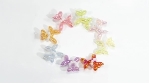 Detailed macro view of 8 colorful metallic balloon dog charms with pearl collar accents